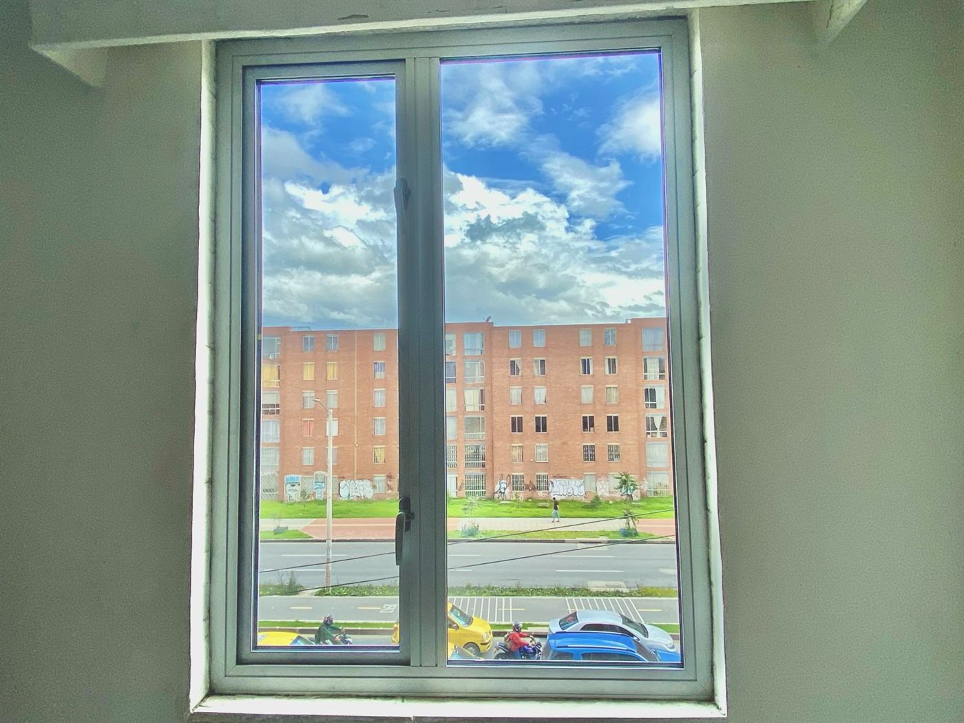 Ventana acústica instalada por Lugcel frente a una avenida de Bogotá con taxis y motos