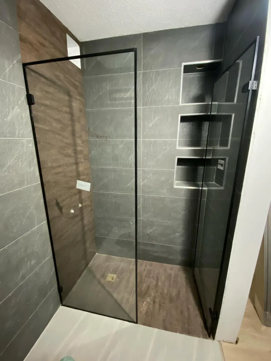 División de baño en vidrio templado con marco de aluminio negro