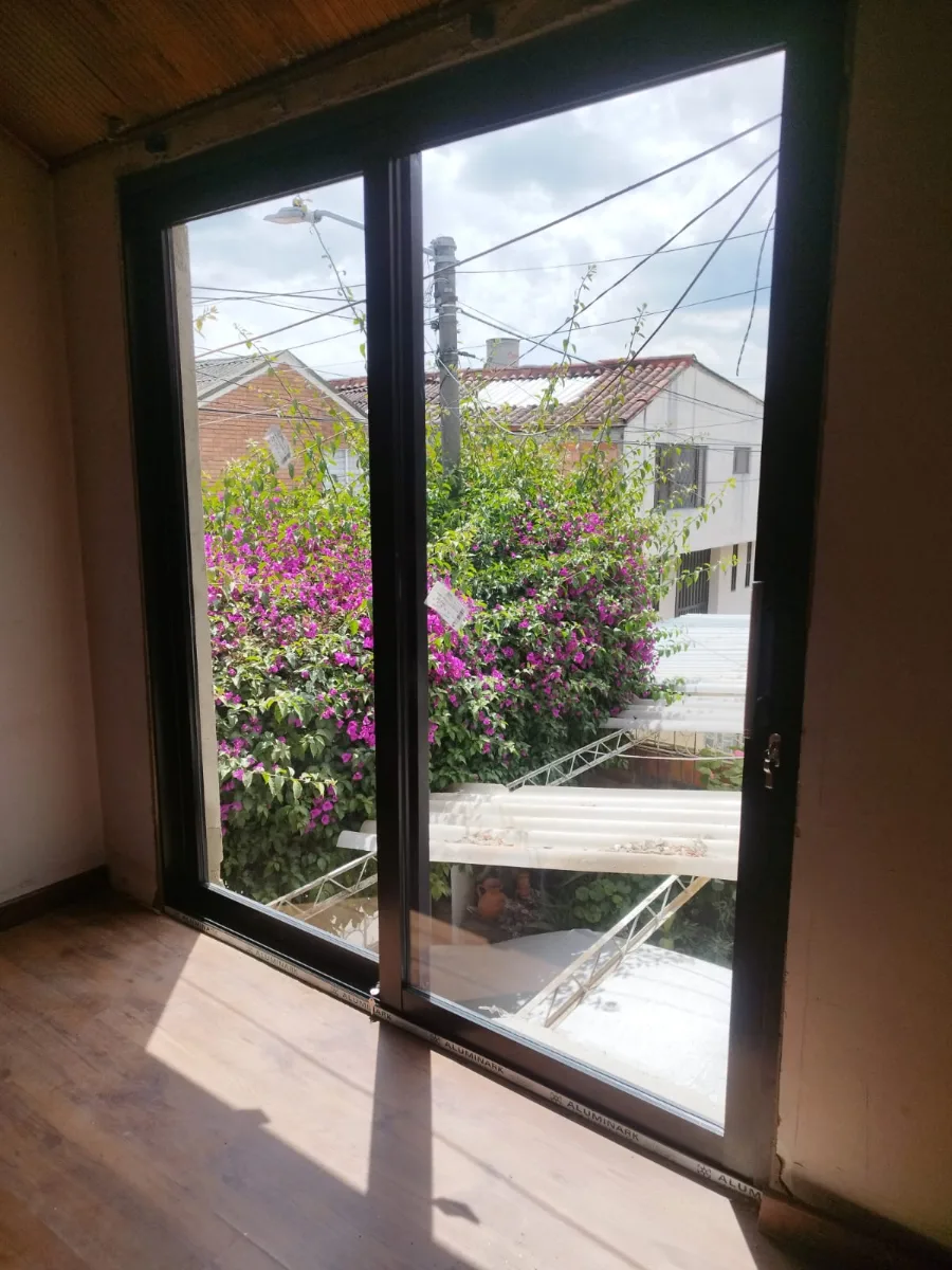 Puerta-ventana corrediza de aluminio negro que da a un jardín